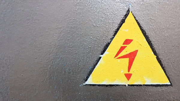 safety sign yellow and red on a silver metal background. High voltage lightning in a triangle caution caution danger electricity death