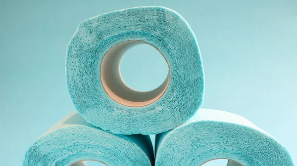 Blue roll of modern toilet paper on a blue background. A paper product on a cardboard sleeve, used for sanitary purposes from cellulose with cutouts for easy tearing. Embossed drawing.