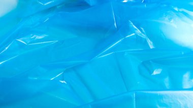 Mavi plastik torba dokusu ve arka plan. Çöp konteynırlarına konacak şekilde tasarlanmış ve evde kullanılıp çeşitli çöp konteynırlarına konan bir torba.