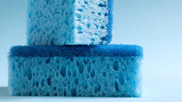 Two blue sponges used for washing and erasing dirt used by housewives in everyday life. They are made of porous material such as foam. Detergent retention, which allows you to spend it economically.
