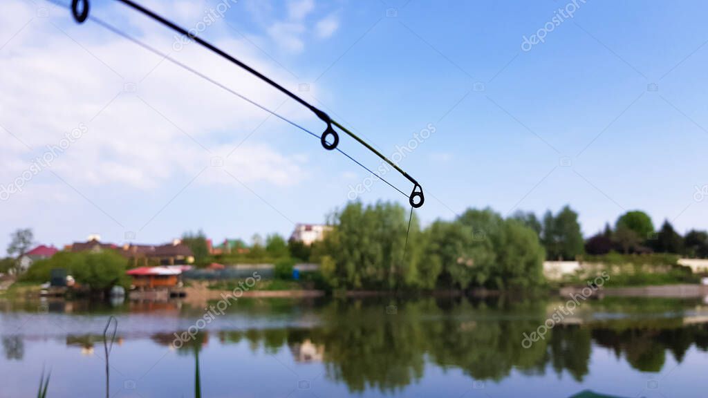 Fishing rod on the background of a beautiful lake in the background