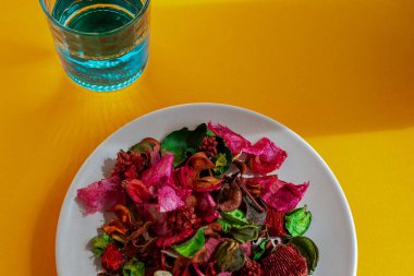 Renkli masada tabak, cam ve çatal bıçak ile modern sofra takımı.