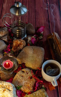 Çay, tütsü çubuğu ve renkli masada aromatik mum ve doğal süslemelerle rahatlatıcı bir mola.