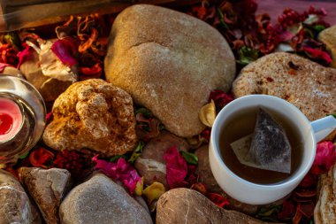 Çay, tütsü çubuğu ve renkli masada aromatik mum ve doğal süslemelerle rahatlatıcı bir mola.