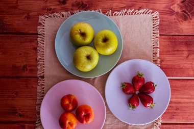 Taze mevsimlik meyve ve fındıklar terracotta tencerelerinde ve renkli seramik tabaklarda