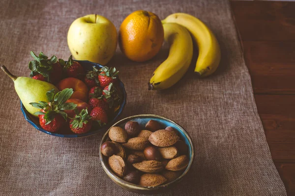 色彩艳丽的陶瓷餐具中新鲜的季节性水果和坚果 — 图库照片