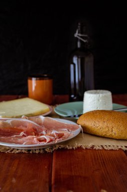 Hünerli bira, peynir, taze meyve, tahıllı ekmek ve çiğ jambon.