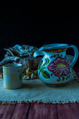 Tahta genişliğindeki doğal dekorasyonda içecekler için seramik sürahi.