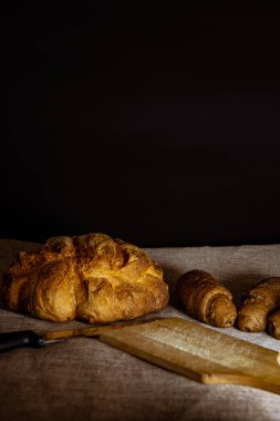 Mısır gevreğiyle ev yapımı ekmek ve ekmek şekli ve dişli bıçakla tahta kesmek.