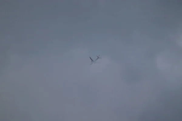 Літак, що проходить у хмарне небо. Комерційний літак, що летить над хмарами під час драматичного заходу сонця. Дуже висока роздільна здатність зображення — стокове фото