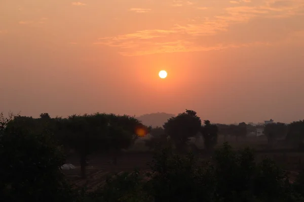 Bewölkter Himmel bei Sonnenuntergang mit der orangen Sonne — Stockfoto