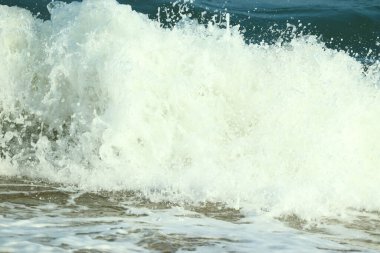 Güneş yansımalı mavi okyanus manzarası berrak gökyüzü ve büyük su dalgası.
