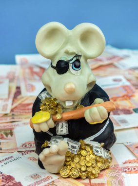Domuz kumbarası faresi paranın üzerinde oturuyor. Yeni yılın sembolü.