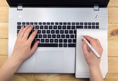 Kız dizüstü bilgisayarın klavyesinde yazıyor. Elinizde bir not defteri var. Kızın bilgilerini yazdığı bir defter.