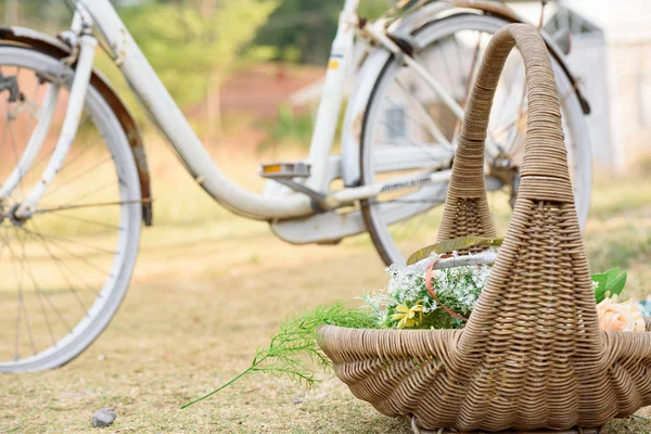 Bahçeye eski bisiklet arka planına sahip sepetli buket.