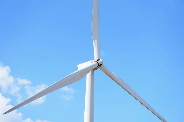 Rüzgar türbinlerine yakın çekim, mavi gökyüzü arka planına sahip rüzgar gücü dönüştürücüleri.