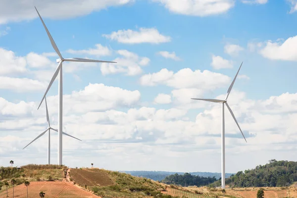 Tepedeki mavi gökyüzü arka planlı rüzgar türbini, dağdaki elektrikli yel değirmeni
