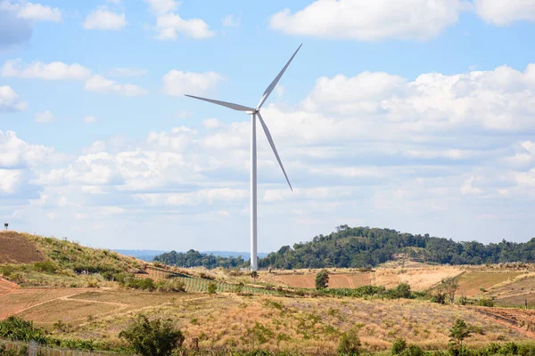 Tepedeki mavi gökyüzü arka planlı rüzgar türbini, dağdaki elektrikli yel değirmeni