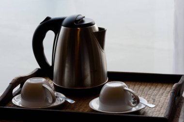Otel odasında elektrikli çaydanlık ve kahve fincanı seti, seramik bardak seti.,