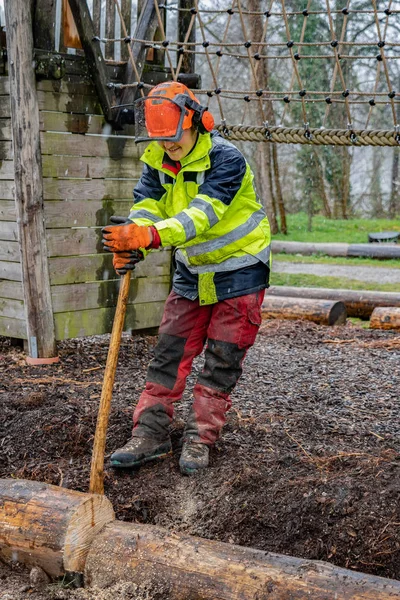 年轻的伐木工人拿着树干在雨天用链锯砍树. — 图库照片