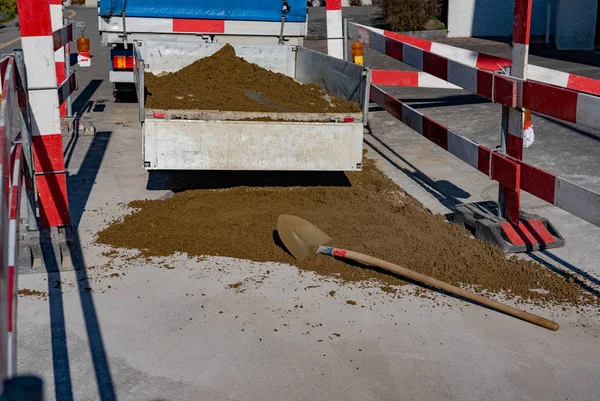 Remolque en obra con portón trasero abierto y arena en la calle . — Foto de Stock