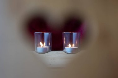 Sevgililer günü, ahşap koltukta bir gözetleme deliğinin bulanık kalbi ve odaklanmış arka planda mum camı..