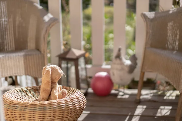 毛绒玩具复活节兔子坐在阳台上的草椅上 望着太阳 高角镜 — 图库照片