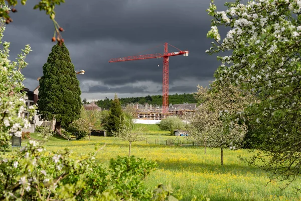 Red crane in stormy weather with sunlight. New residential district in Brugg, Switzerland.