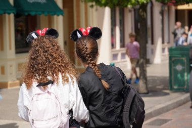 İki genç kızın kafasının arkasında. Turist parkında diğer ziyaretçilerle birlikte sokakta kalmak. Paris Fransa, 29 yaşında. Mayıs 2019
