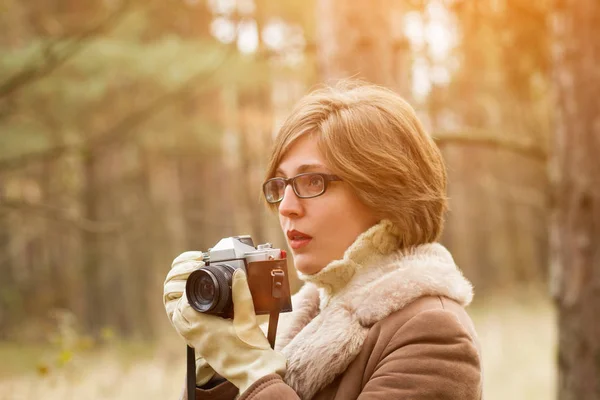 Elegant young woman taking photo in the forest — Stock Photo, Image