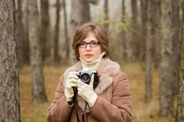 Elegant young woman taking photo in the forest — Stock Photo, Image