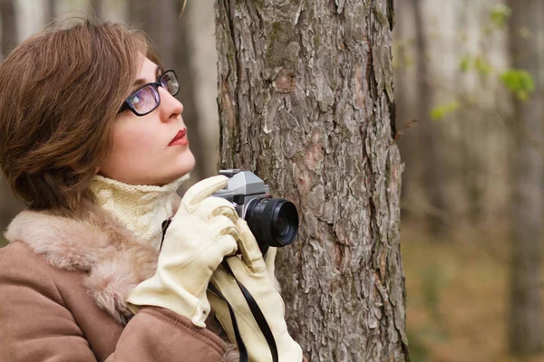 Mujer joven tomando fotos en el bosque — Foto de Stock