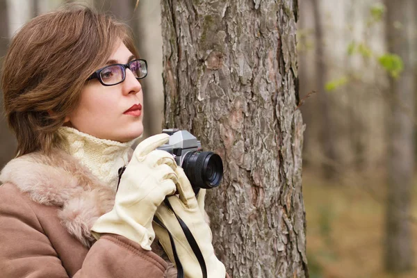 Mujer joven tomando fotos en el bosque — Foto de Stock