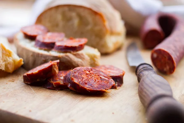 Knife,  fresh bread and sausage on the table — Stock Photo, Image