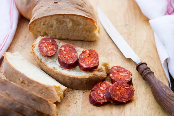 刀、 新鲜面包和香肠在桌子上 — 图库照片