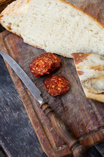 Coltello, pane fresco e salsiccia in tavola — Foto Stock