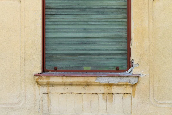 Gele Grunge Muur Met Groene Rolluiken — Stockfoto