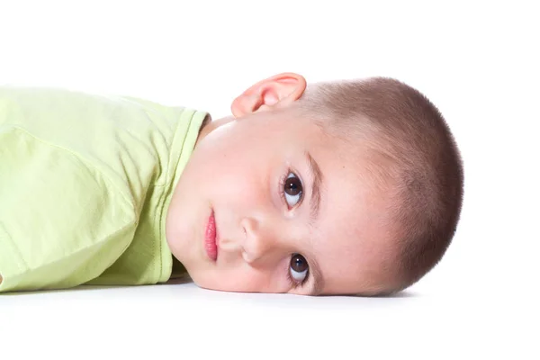 Boy is lying on the white — Stock Photo, Image