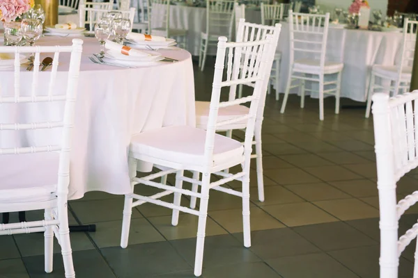 fancy table set for a wedding dinner, white chairs