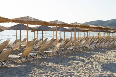 Şemsiyeli boş plaj ve boş güneşlikler.