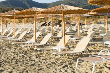 Şemsiyeli boş plaj ve boş güneşlikler.