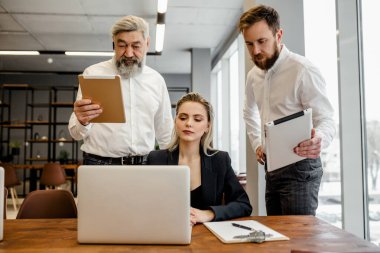Ekip ofiste karmaşık bir iş sözleşmesi üzerinde çalışıyor.