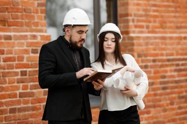 Mühendis bir kız iş toplantısında Arap bir mühendis ile çalışma anlarını tartışıyor.