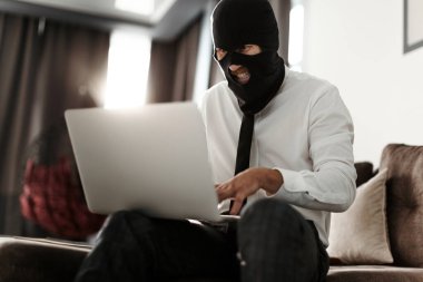 Kar maskeli ve beyaz ofis gömlekli bir adam laptopun başında oturuyor ve anonim olarak bir akarsu için yaşamaya çalışıyor.