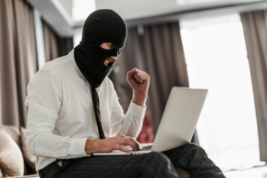 Kar maskeli ve beyaz ofis gömlekli bir adam laptopun başında oturuyor ve anonim olarak bir akarsu için yaşamaya çalışıyor.
