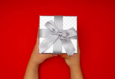 Çocukların elleri gümüş bir hediye tutuyor.