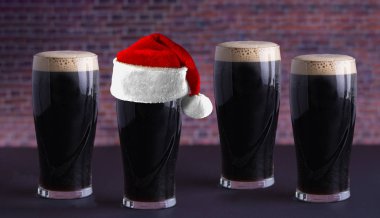 A Guinness dark Irish dry stout beer glass with a santa hat clipart