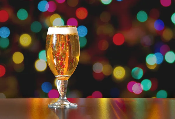 A Cup of Stella Artois full of beer with holiday colorful lights in background — Stock fotografie