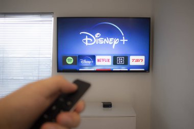Calgary, Alberta. Kanada 5 Aralık 2019: Vizio TV 'deki yeni Disney + uygulamasını kullanan kişi Apple TV kumandası taşıyor. Disney + video yayınlama servisi sadece Yıldız Savaşları 'nı gösterecek: Jedi Şablon Yarışması. 