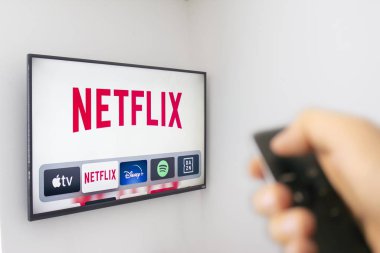 Calgary, Alberta. Kanada 9 Aralık 2019: Bir kişi yeni Netflix uygulamasını kullanarak bir Apple TV kumandası tutuyor. Netflix Altın Küre adaylıklarına hükmediyor. Çizimsel